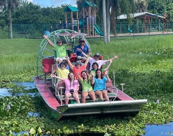 Group of people on an airboat in front of the play ground at the Lake Washington Park